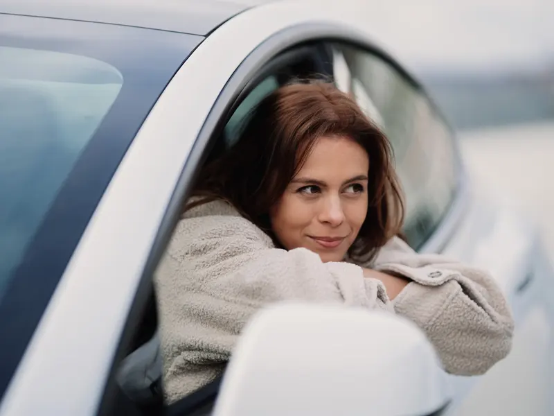 Woman hanging out of car window
